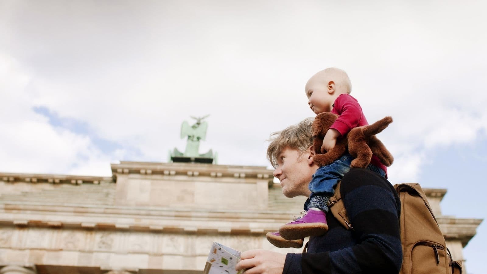Man with little baby on his shoulders in front of Brandenburger Tor in Berlin